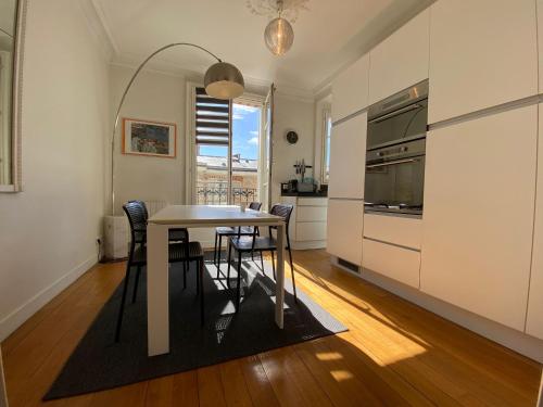 une cuisine et une salle à manger avec une table et des chaises dans l'établissement Nice Sunny Central Paris, à Paris
