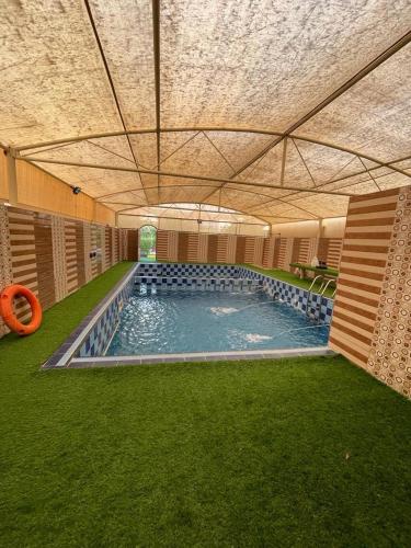 une piscine intérieure avec un tube orange dans un bâtiment dans l'établissement Al Bayan Inn, à Nizwa