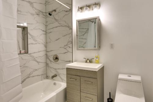 a bathroom with a sink and a tub and a toilet at Chic Newark Vacation Rental 3 Mi to Airport! in Newark