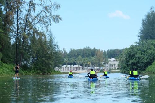 a group of people kayaking down a river at Devasom Khao Lak Beach Resort & Villas in Khao Lak