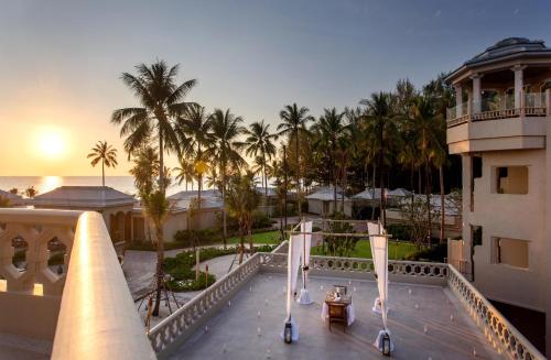 a view from a balcony of a resort with palm trees at Devasom Khao Lak Beach Resort & Villas in Khao Lak