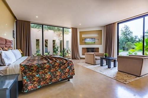 a large bedroom with a bed and a living room at Villa Marrakech Palmeraie Lux in Marrakech