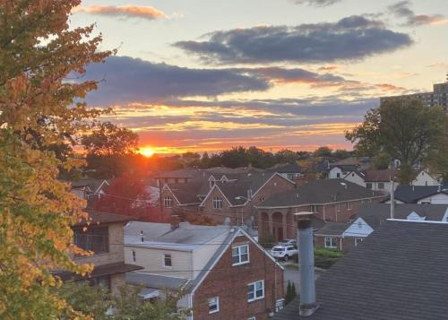 una puesta de sol sobre un barrio residencial con casas en Cozy Room in Fort Lee, en Fort Lee