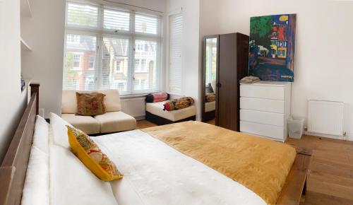 1 dormitorio con 1 cama grande y sala de estar en Central Location 2 bed flat, Zone II, London NW6 en Londres