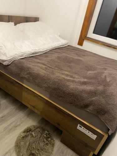 1 cama con marco de madera y alfombra en Natura Dom Iwona Przybysz, en Kaplityny