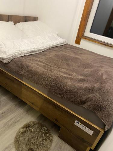 a bed with a wooden frame and a rug at Natura Dom Iwona Przybysz in Kaplityny