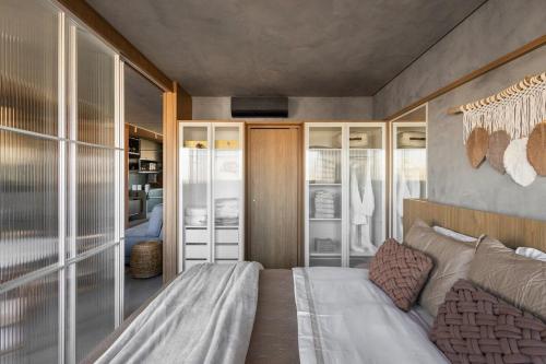 um quarto com uma cama grande e portas de vidro em Studio Bali em Campo Grande