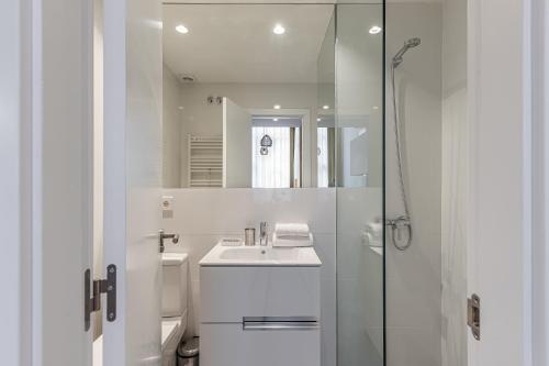 y baño blanco con lavabo y ducha. en BNBHolder Modern Loft III Centre, en Madrid
