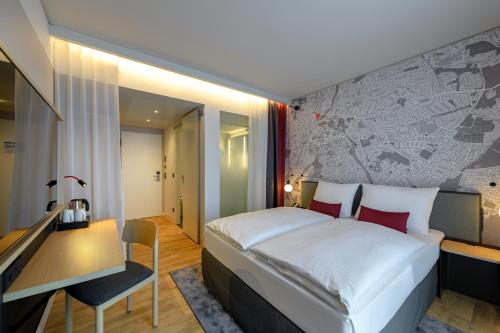 a hotel room with a bed and a desk and a bedroom at IntercityHotel Herford in Herford