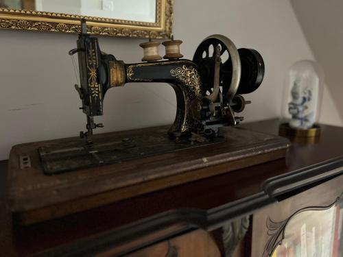 an old sewing machine on a table with a mirror at Liverpool Victorian Townhouse - 3 Bedrooms in Liverpool