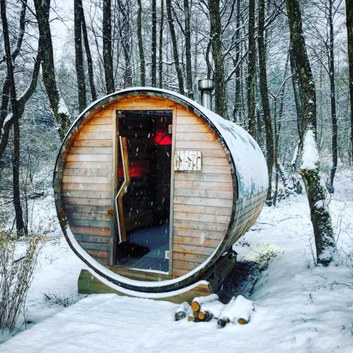 a small wooden cabin in the woods in the snow at Le Sanglier Amoureux in Érezée