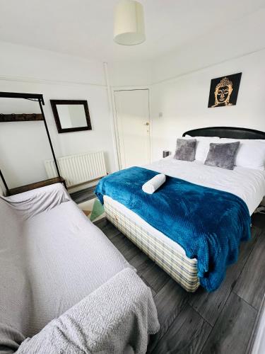 a bedroom with two beds with blue and white sheets at Spacious Town House in Wyken