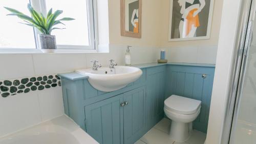 Baño azul con lavabo y aseo en Gwyndy Bach en Trearddur