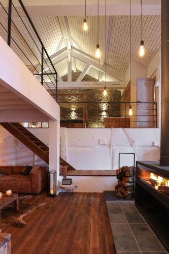 a living room with a staircase and a couch at Le Sanglier Amoureux in Érezée