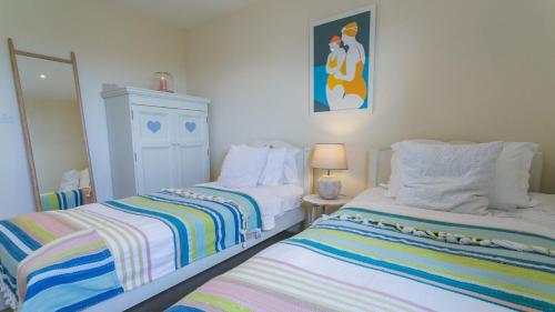 two beds sitting next to each other in a room at Gwyndy Bach in Trearddur