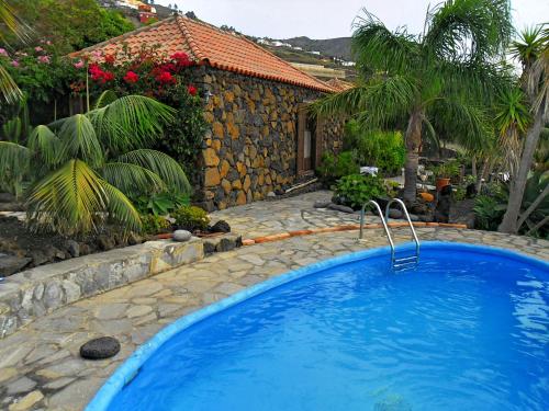 uma grande piscina azul em frente a uma casa em Finca del Sur em Las Indias