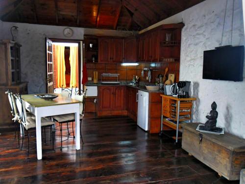 uma cozinha com armários de madeira e uma mesa com cadeiras em Finca del Sur em Las Indias