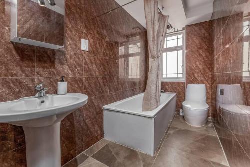 a bathroom with a sink and a tub and a toilet at Lovely 2 BR with patio Waterloo LM1 in London