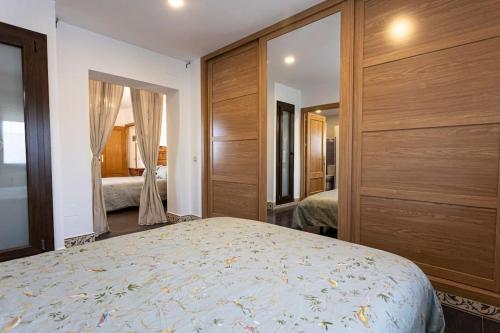 una camera da letto con un grande letto e pareti in legno di Casa Rural El Abuelo Mauri En Toledo a Mascaraque
