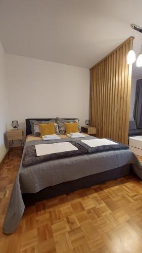 duże łóżko w pokoju z drewnianą podłogą w obiekcie BMM LUX APARTMENT w mieście Voždivac