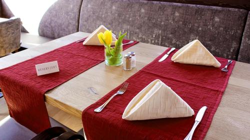 a wooden table with a red table cloth on it at Hotel Gasthof Adler in Ulm