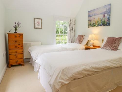 1 dormitorio con 2 camas, vestidor y ventana en Mountfield Farm Cottage en Wavehorne