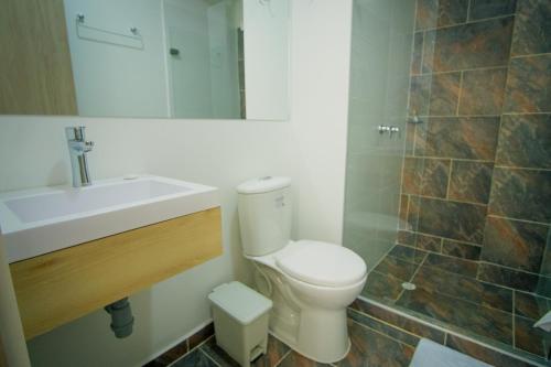 ein Badezimmer mit einem WC, einem Waschbecken und einem Spiegel in der Unterkunft HOTEL EL NARANJO in Acacías