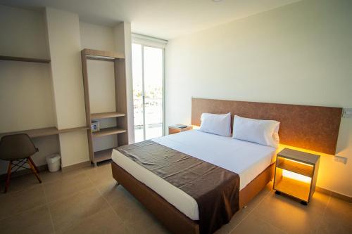 sypialnia z dużym łóżkiem i oknem w obiekcie HOTEL EL NARANJO w mieście Acacias
