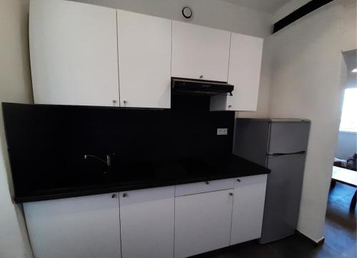 une cuisine avec des armoires blanches et un comptoir noir dans l'établissement studio centre ville vue exceptionnelle, à Bastia
