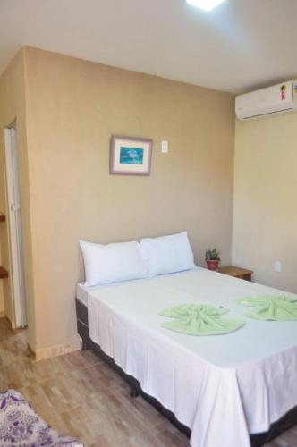 um quarto com uma grande cama branca num quarto em Luamar Chalés em São Miguel do Gostoso