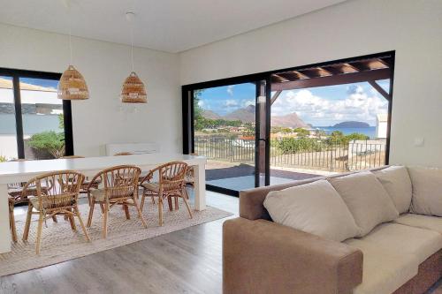 a living room with a couch and a table with chairs at Oásis by BCA Villas in Porto Santo