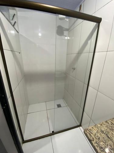 La salle de bains est pourvue d'une douche avec une porte en verre. dans l'établissement Hostel Araxá, à Araxá