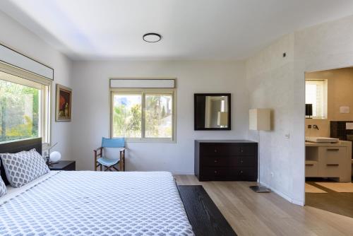 a bedroom with a bed and a desk and a mirror at Maison d architecte in Herzelia 