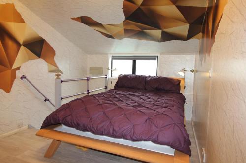 ブライトン＆ホーブにあるFantastic Waterside apartment in Brighton Marinaの幾何学的な天井の客室のベッド1台分です。