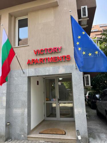 uma bandeira e uma bandeira europeia em frente a um edifício em APARTHOTEL VICTORY SOFIA em Sófia