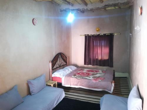 a small room with a bed and a couch at Gite Amoudou in Ouarzazate