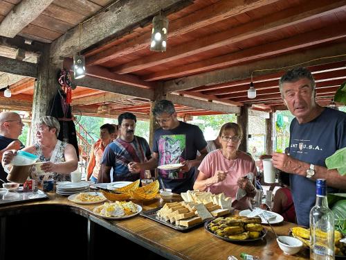 a group of people standing around a table with food at VuLinh Family -Homestay in Yên Bình