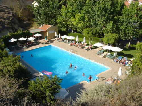 an overhead view of a swimming pool with people in it at Kotzias Beach Apartments in Pissouri