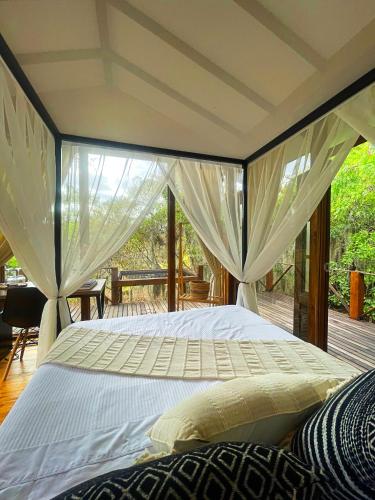 a bedroom with a large white bed with curtains at Hotel La Villa de Victoria Villa de Leyva in Sáchica