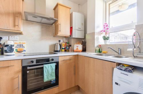 cocina con fogones y fregadero en Fresh Apartment & Parking, en Londres