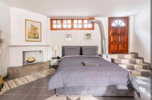 a bedroom with a large bed and a fireplace at Stunning studio near center of athens in Athens
