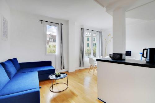 sala de estar con sofá azul y cocina en Superb 2BR apartment - Suresnes en Suresnes