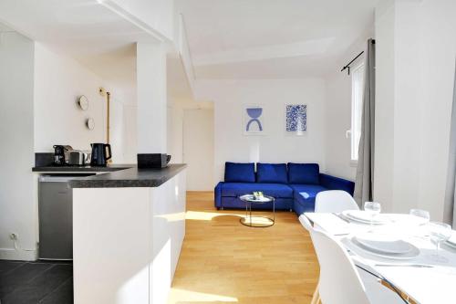 cocina y sala de estar con sofá azul en Superb 2BR apartment - Suresnes en Suresnes