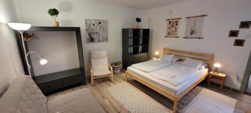 - une chambre avec un lit et une chaise dans l'établissement Zrínyi 11 Apartments, à Balatonkenese