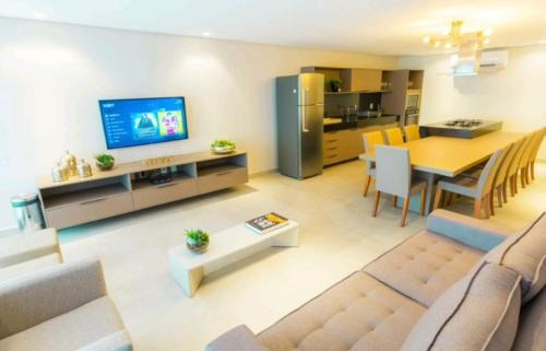 a living room with a table and a dining room at Flat Eco Summer Tambaú Apto 2Qts, Cozinha completa in João Pessoa