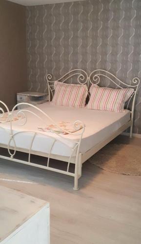 a white bed with two pillows on it at Guest rooms KRASI in Strazha