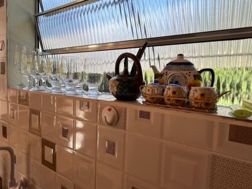 a shelf with wine glasses and dishes on it at Casa Kiiro, um ambiente tranquilo e de sossego. in Santo Antônio do Pinhal