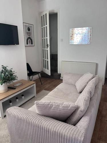 a living room with a couch and a tv at Inviting Town House in Coventry