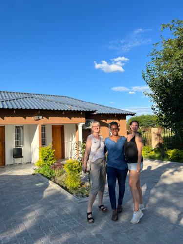 a group of three people standing in front of a house at Jayla Homestay in Maun