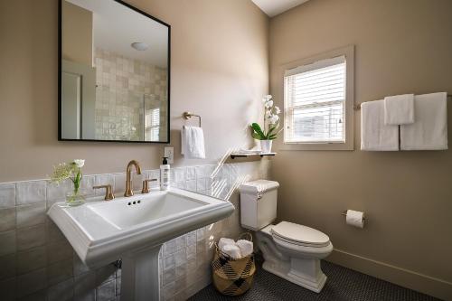 ein Badezimmer mit einem Waschbecken, einem WC und einem Spiegel in der Unterkunft The Neighborhood Hotel New Buffalo in New Buffalo
